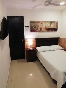 1 dormitorio con 2 camas y puerta negra en Apto amoblado barrio Los Alpes Cartagena, en Cartagena de Indias