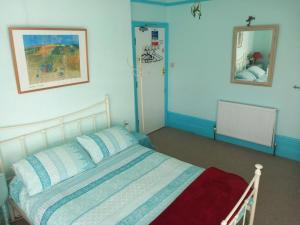 1 dormitorio con cama y espejo en Falmouth Lodge, en Falmouth