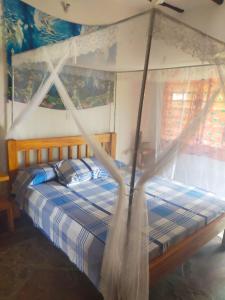 ein Schlafzimmer mit einem Himmelbett in der Unterkunft SAMAKI VILLAGE in Watamu