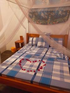 瓦塔姆的住宿－SAMAKI VILLAGE，一间卧室,床上有红色的鲜花