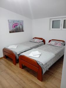 2 camas en una habitación con una foto en la pared en Apartman M Batajnica, en Batajnica