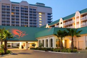 a hotel with palm trees in front of a building at Daytona Beach Resort in Daytona Beach
