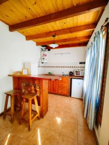 a kitchen with wooden ceilings and a counter and stools at La Herreria 2 in Esquel