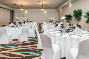 a banquet room with white tables and white chairs at Daytona Beach Resort in Daytona Beach