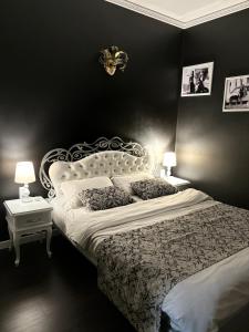 リヴィウにあるApartment Blue Dreamsの白いベッドと黒い壁のベッドルーム1室