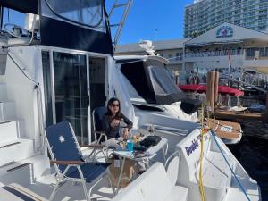 a woman sitting at a table on a boat at Delightful 2 Bdrm Sport Yacht with Pool in Pompano Beach