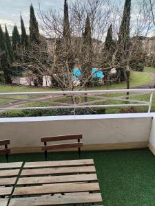 two benches sitting next to a wall with trees at T4 spacieux+2 terrasse vue sur picine+parking gratuit in Gagnac-sur-Garonne