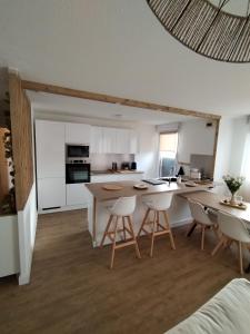 a kitchen with white cabinets and a table and chairs at T4 spacieux+2 terrasse vue sur picine+parking gratuit in Gagnac-sur-Garonne