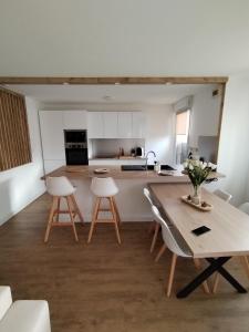 una cucina con tavolo e sedie in una stanza di T4 spacieux+2 terrasse vue sur picine+parking gratuit a Gagnac-sur-Garonne