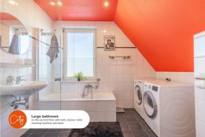 a bathroom with a washing machine and a sink at 10 min to Amsterdam Sauna Jacuzzi BBQ & Disco in Zwanenburg