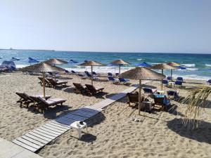 een strand met stoelen en parasols en de oceaan bij Casa dei Maestri in Perivólia