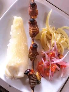 eine Platte mit Fleisch, Käse und Gemüse in der Unterkunft Sacha Huasi in Tena