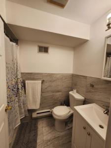 a bathroom with a toilet and a sink at Sophisticated 4-Bed Apt Close to NYC in Jersey City