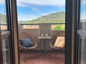 two chairs and a table on a balcony with a view at Appartamento con vista in Brescia