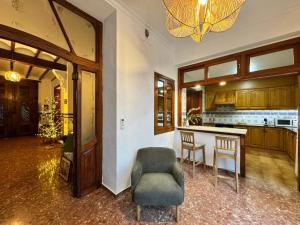 een woonkamer met een stoel en een keuken bij Casa Villalonga in Villalonga