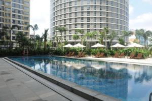 a large swimming pool in a city with tall buildings at Bluesky Serviced Apartment Airport Plaza in Ho Chi Minh City