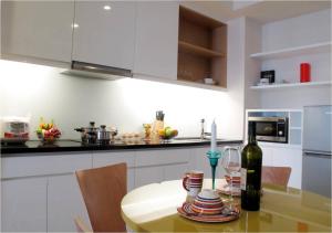 a kitchen with a table with a bottle of wine at Bluesky Serviced Apartment Airport Plaza in Ho Chi Minh City
