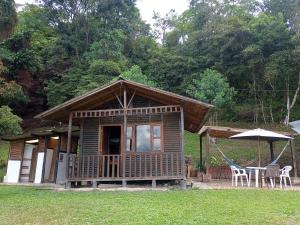 a small cabin with a table and an umbrella at Eco-Cabañas Altozano Nimaima in Nimaima