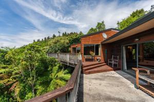 a wooden house with a porch and a deck at Pukawa Paradise - Pukawa Holiday Home in Kuratau
