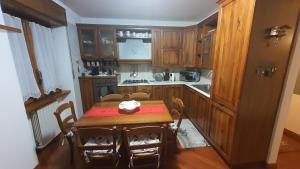 a kitchen with a wooden table and a table and chairs at Rendena Dolomiti House CIPAT 022244-AT-012660 in Porte di Rendena