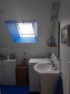 a bathroom with a sink and a window at Chez Édouard et Aline in Ploubazlanec