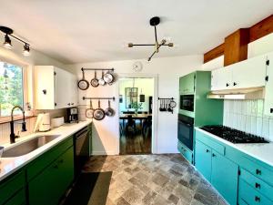 a kitchen with green cabinets and a sink at Spacious Retreat w/ Hot Tub. Perfect for Families in Edmonds