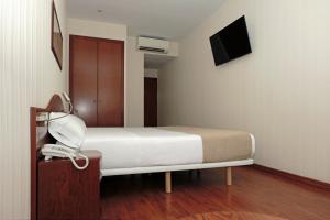 Un pat sau paturi într-o cameră la Hotel Belcaire