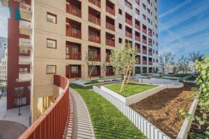 an apartment building with a garden in front of it at CHARMING APARTMENT WITH PANORAMIC SEINE RIVER & EIFFEL TOWER VIEWs in Ivry-sur-Seine