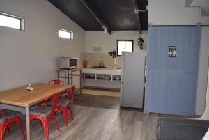 a kitchen with a table and a refrigerator at Clayhouse Rivadavia in Rivadavia