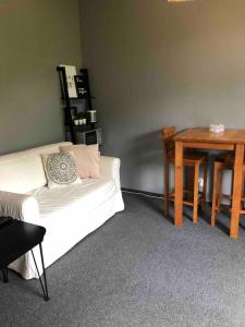 a living room with a white couch and a table at Hässleholm med närhet till strövområde och sjö in Tormestorp