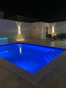 una piscina azul en una casa por la noche en Luxury in Paradise 2, en San Felipe de Puerto Plata