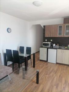 uma cozinha e sala de jantar com mesa e cadeiras em Двустаен апартамент em Sveti Vlas