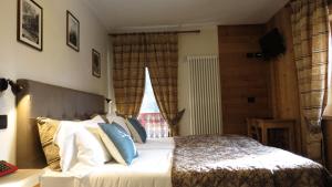 Un dormitorio con una cama grande y una ventana en Hotel Astoria, en Courmayeur