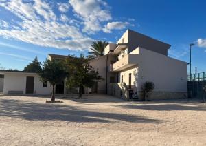 a white building with a palm tree in front of it at B&B ILSE in Capua