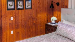 a bedroom with a bed and a wooden wall with pictures at Little Smoky Retreat , 3 Bedroom , Close to downtown Gatlinburg AND Pigeon Forge in Gatlinburg
