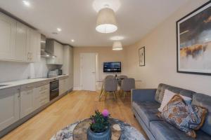 a living room with a blue couch and a kitchen at Modern 2 Bed Apartment - Allocated Parking in Windsor