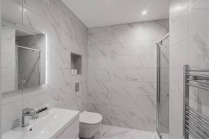 a white bathroom with a sink and a shower at Modern 2 Bed Apartment - Allocated Parking in Windsor