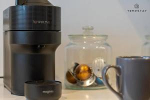 a kitchen counter with a coffee maker and a bowl of fruit at Modern 2 Bed Apartment - Allocated Parking in Windsor