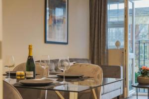 a table with glasses and a bottle of wine on it at Modern 2 Bed Apartment - Allocated Parking in Windsor +3 photos