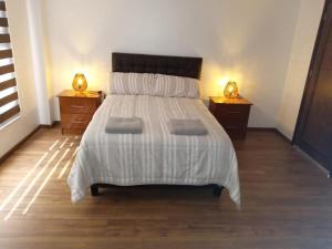1 dormitorio con 1 cama grande y 2 mesitas de noche en San Martin Resort, 