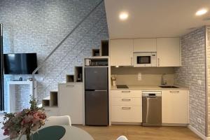 a kitchen with white cabinets and stainless steel appliances at Hola Pamplona! in Pamplona