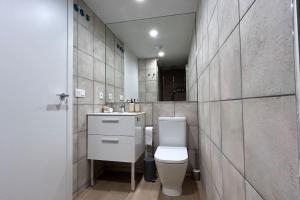 uma casa de banho com um WC, um lavatório e um espelho. em Hola Pamplona! em Pamplona