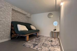 uma sala de estar com uma cadeira verde e uma parede de tijolos em Hola Pamplona! em Pamplona