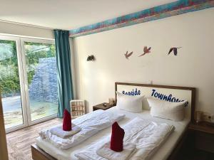 1 dormitorio con 2 almohadas rojas en una cama en Seaside-Townhouse en Timmendorfer Strand