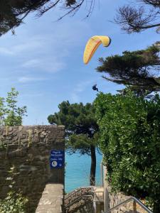 une personne vole un cerf-volant au-dessus de l'océan dans l'établissement Lescale Donvillaise, à Donville-les-Bains