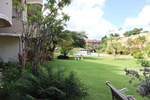 un parque con un banco en medio de un patio en 1 habitation piscina boca chica en Cuevas