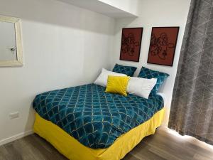 ein kleines Schlafzimmer mit einem Bett mit blauer Decke in der Unterkunft Bertiz Cozy in Guatemala