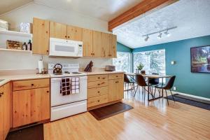 a kitchen with wooden cabinets and a table with chairs at Solitude Mountain Cabin Creek-Side View and Hot Tub in Brighton