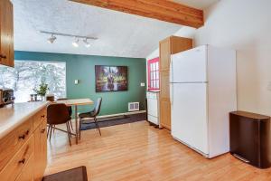 a kitchen with a white refrigerator and a table at Solitude Mountain Cabin Creek-Side View and Hot Tub in Brighton