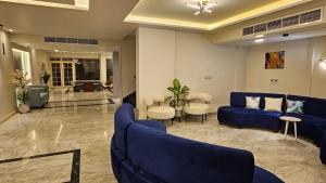 a living room with a blue couch and chairs at Luxury Accommodation in Sheikh Zayed